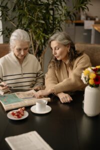 Des femmes âgées résolvent des mots croisés, favorisant l'amitié et la stimulation mentale à l'intérieur.
