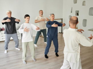 Un groupe de seniors suit attentivement un professeur pour une session de danse adulte axée sur la fluidité et l'équilibre