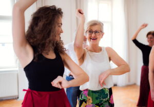 Deux femmes de générations différentes s'exercent avec enthousiasme lors d'un cours de danse adulte en studio
