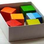 Des cubes de couleur dans une boîte blanche sur un fond clair
