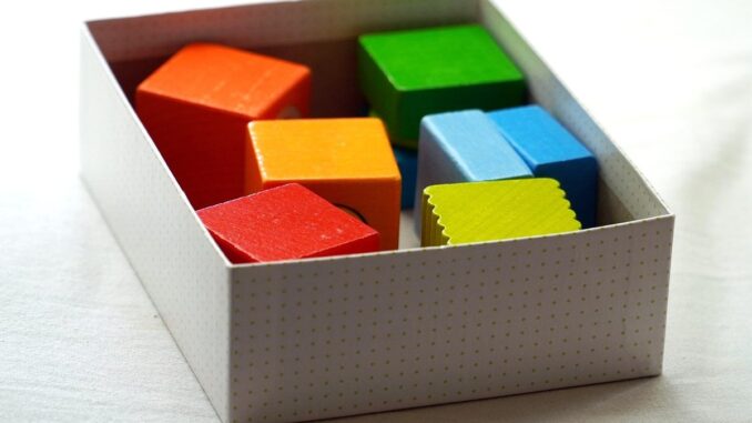 Des cubes de couleur dans une boîte blanche sur un fond clair