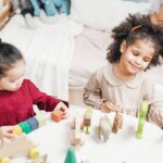 Enfants manipulant des blocs en bois sur une table dans une pièce