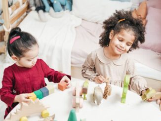 Enfants manipulant des blocs en bois sur une table dans une pièce