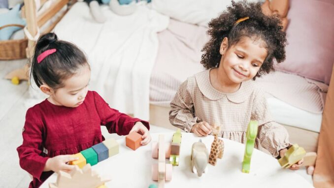 Enfants manipulant des blocs en bois sur une table dans une pièce