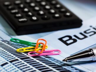 Calculatrice, papier, stylo et trombones colorés sur document d'entreprise